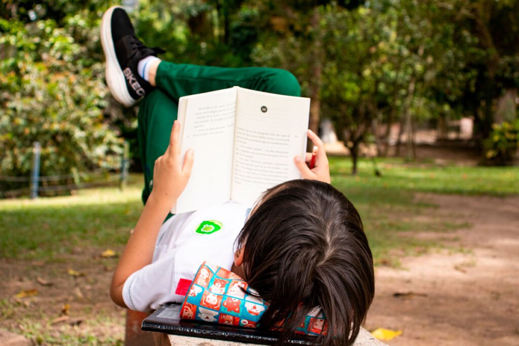 niño leyendo al aire libre